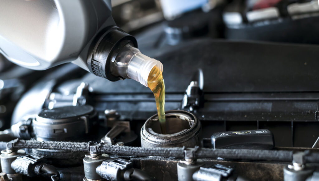Pouring synthetic motor oil in diesel engine.