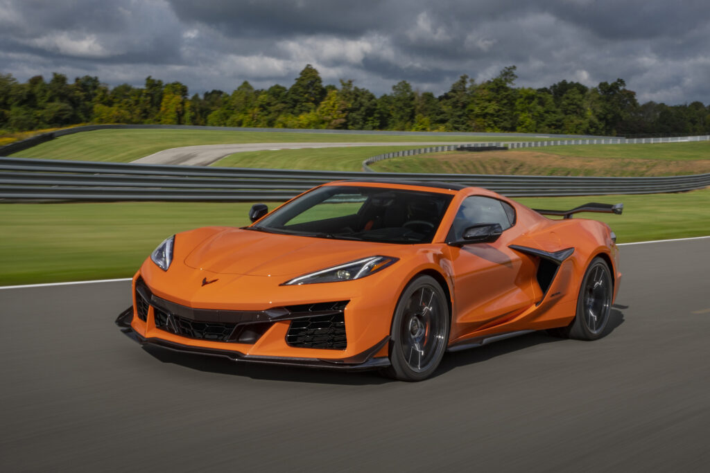 Front 3/4 view of a 2024 Chevrolet Corvette Z06 in Amplify Orange Tintcoat driving on a track.